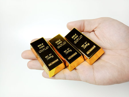 Hand holding gold bars on white background, closeupの写真素材