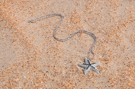 Pendant a star on sea sandの写真素材