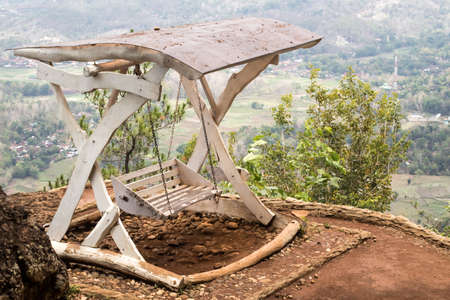 Hanging chairs on the edge of a beautiful cliffの写真素材