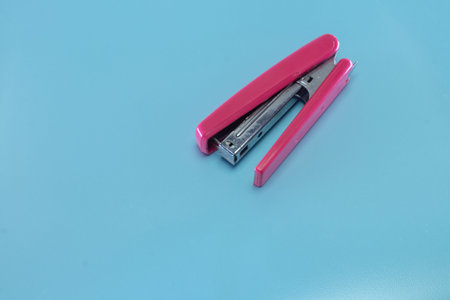 A pink staple on a light blue background