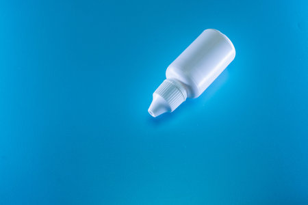 Bottle of white drops on a blue background