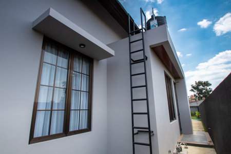 Ladder on the wall of a modern house with a blue sky