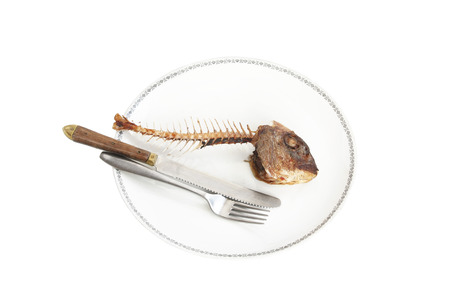 Fish skeleton on the plate - symbol for food shortageの写真素材
