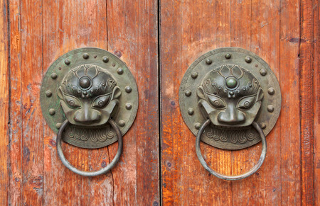 Double lion knobs on an old wood doorの写真素材