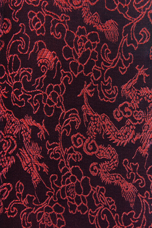 Dragon patterns on dark red-black silk textileの写真素材