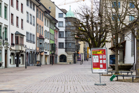 Schaffhausen, Switzerland - March 29. 2020: Information sign by the Swiss Federal Office of Public Health: How we protect ourselves against Coronavirus and the empty town center during covid-19 lockdown.のeditorial素材