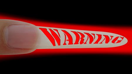 Warning signal on long finger nail symbols high risk of brokenの写真素材