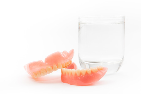 a denture is cleaned in a glass of water. proper hygiene.の写真素材