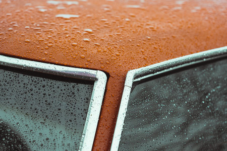 orange car roof with chroming trim soaked in the rain