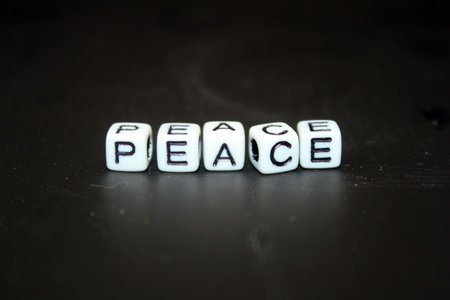 Word Peace made of white dice on a black background with copy space
