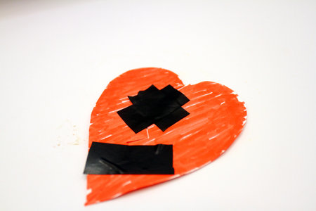 Red heart with adhesive tape on white background.の写真素材