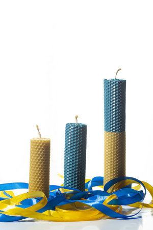 natural wax candles, yellow-blue candles on a white backgroundの写真素材