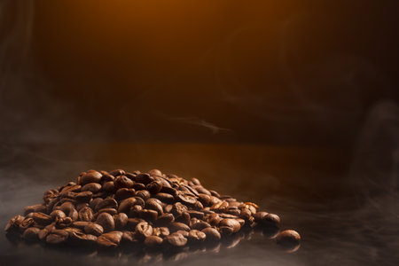 coffee beans on a dark background with a yellow highlight on the background, coffee beans close-up for a coffee shopの写真素材
