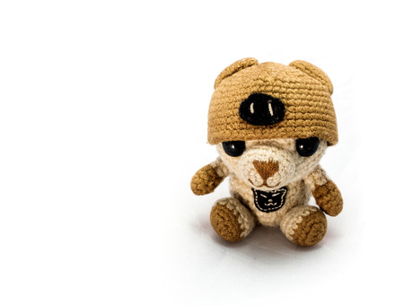 handmade crochet yellow bear doll on white backgroundの写真素材