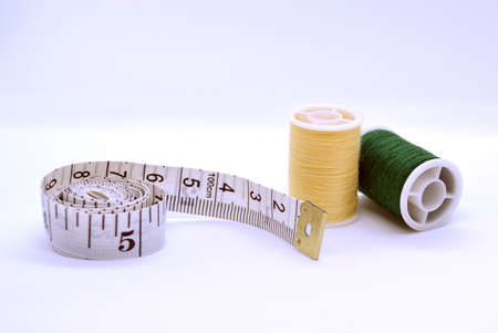 Threads and sewing ruler. In the photo, the threads are yellow and green and a sewing meter.の写真素材