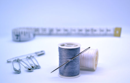 Sewing accessories. In the photo there are colored threads, a needle, a sewing ruler, pins.