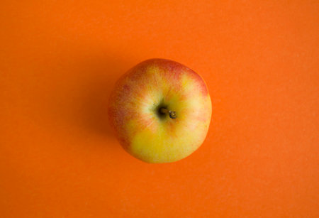 Apple on an orange background close-up, photo.の写真素材