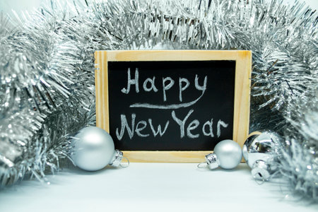 Lettering Happy New Year, Christmas balls and tinsel. Blackboard with the inscription Happy New Year in chalk, Christmas balls and tinsel.の写真素材