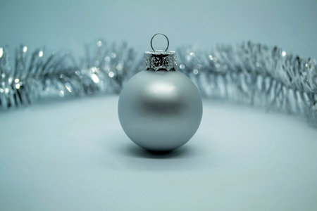 Christmas ball and tinsel. Silver Christmas ball, tinsel on a white background.の写真素材