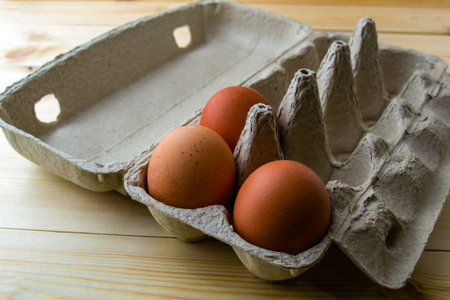 Eggs in a cardboard box. Eggs in a cardboard box on a wooden table.の写真素材