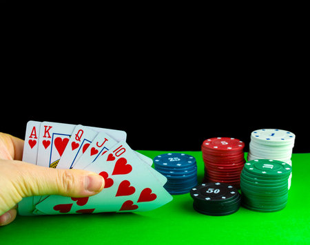 Poker, royal flush in hand. A deck of cards in hand with a combination of royal flush, poker chips...