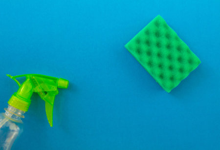cleaning. Flat lay sponge and cleaning product on a blue background. Cleaning supplies top view.