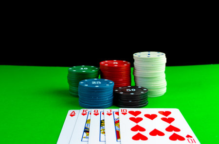 Poker chips in stacks and royal flush cards on the poker table. Cards on the table with a combination of royal flush and poker chips.の写真素材