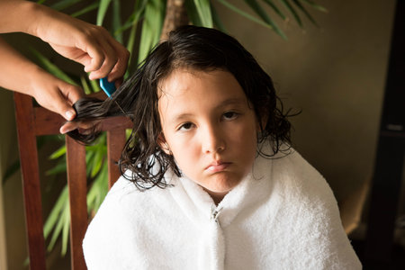 a girl is upset face, she is doing head lice treatment