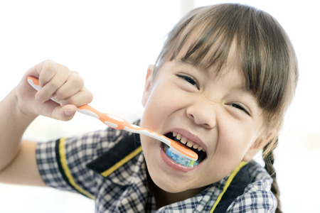 a school uniform girl is brushing her teethの写真素材