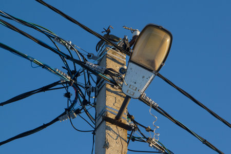 concrete pole with electrical wires and lamp