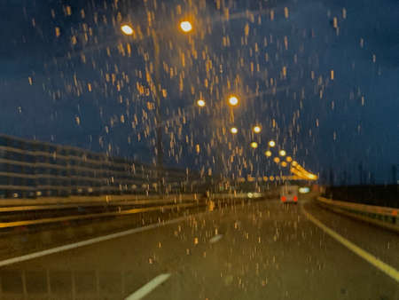Night road in the rain through the glass lights glareの写真素材