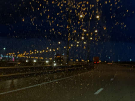 Night road in the rain through the glass lights glareの写真素材