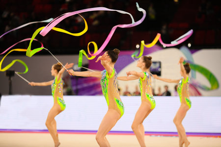 Young gymnasts dance with colored ribbons. Rhythmic gymnastics team competitionsの写真素材