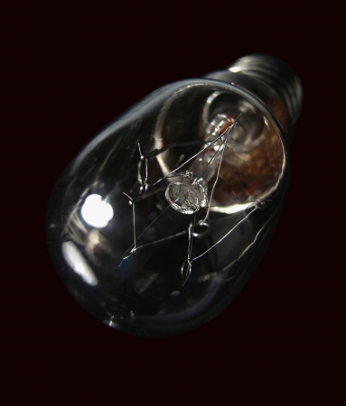 The small electric bulb is against a dark backgroundの写真素材