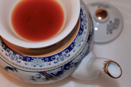 The image of a porcelain teapot and Asian drinking bowl with red tea, macro, the top viewの写真素材