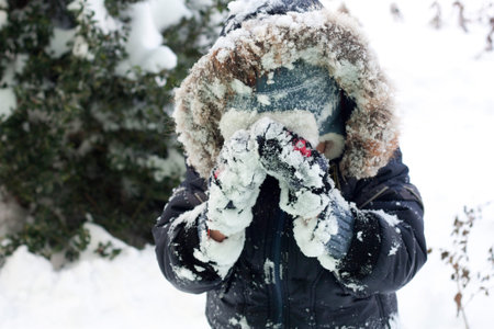 Happy boy playing with snow, good winter day