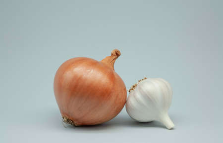 Onion and head of garlic on a gray background close-up. Healthy vegetables. Natural vitamins. For immunity and cooking.の写真素材