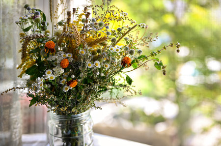 Floral background with copy space. Autumn or summer bouquet of wildflowers. Flowers on the windowsill, sunny day, blurred background. Soft focusの写真素材