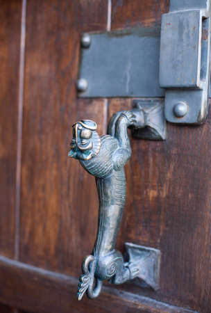 Metal handle on the door of an old monastery close-up. Door handle in the shape of a lion.の写真素材