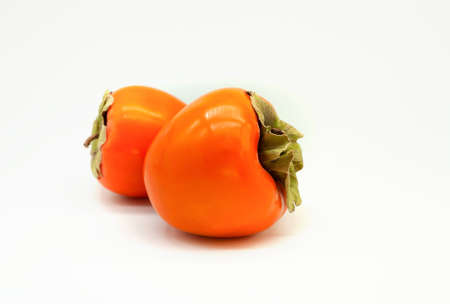 Two persimmons isolated on a white background.の写真素材