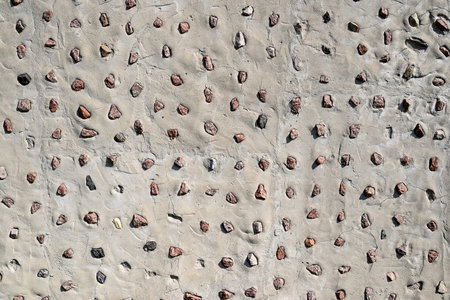 Abstract background. The relief texture of the wall is made of gray cement and small stones (crushed...
