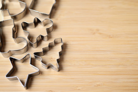 Metal cookie cutters of various shapes for homemade cookies and gingerbread on a wooden background.の写真素材