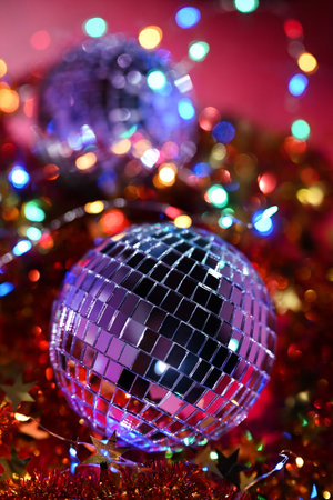 Festive background. Mirrored disco ball on a red background with colorful Christmas lights.の写真素材