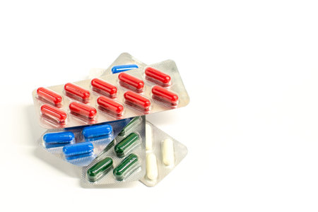 multicolored capsules in a blisters in a white background