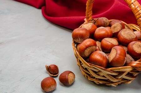 hazelnuts in basket on the light background with red towel. close-up with copy space.の写真素材