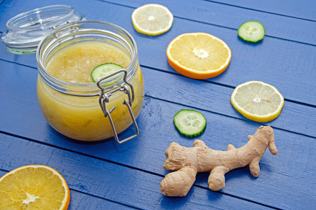 cucumber jam in a glass jar with slices of ingredients of orange, lemon, cucumber and ginger on a...