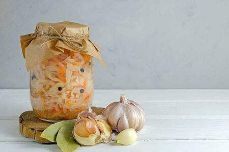 Fermented preserved vegetarian food concept. Homemade marinated cabbage with garlic and pepper, sauerkraut on white background. With copy space.の写真素材