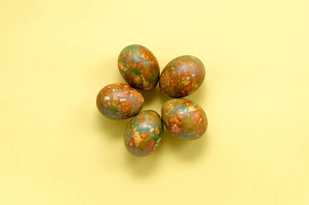 marble modern trendy festive easter eggs in the middle of the frame in the form of a flower on a yellow background with copy space. Easter and spring conceptの写真素材