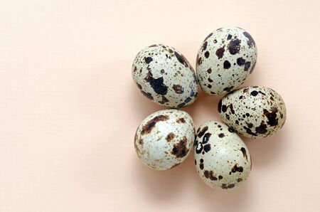 quail eggs laid out in the form of flower on a pink peach background top view with copy space. Easter holiday eggs. The concept of spring, warmth, flowering, love, relationships. universal greetings.の写真素材