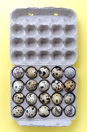 zero waste concept. close-up quail eggs are laid out in a box of recycled materials, recycled cardboard, on a yellow background. concept of healthy diet food and diet. dietary nutritionの写真素材